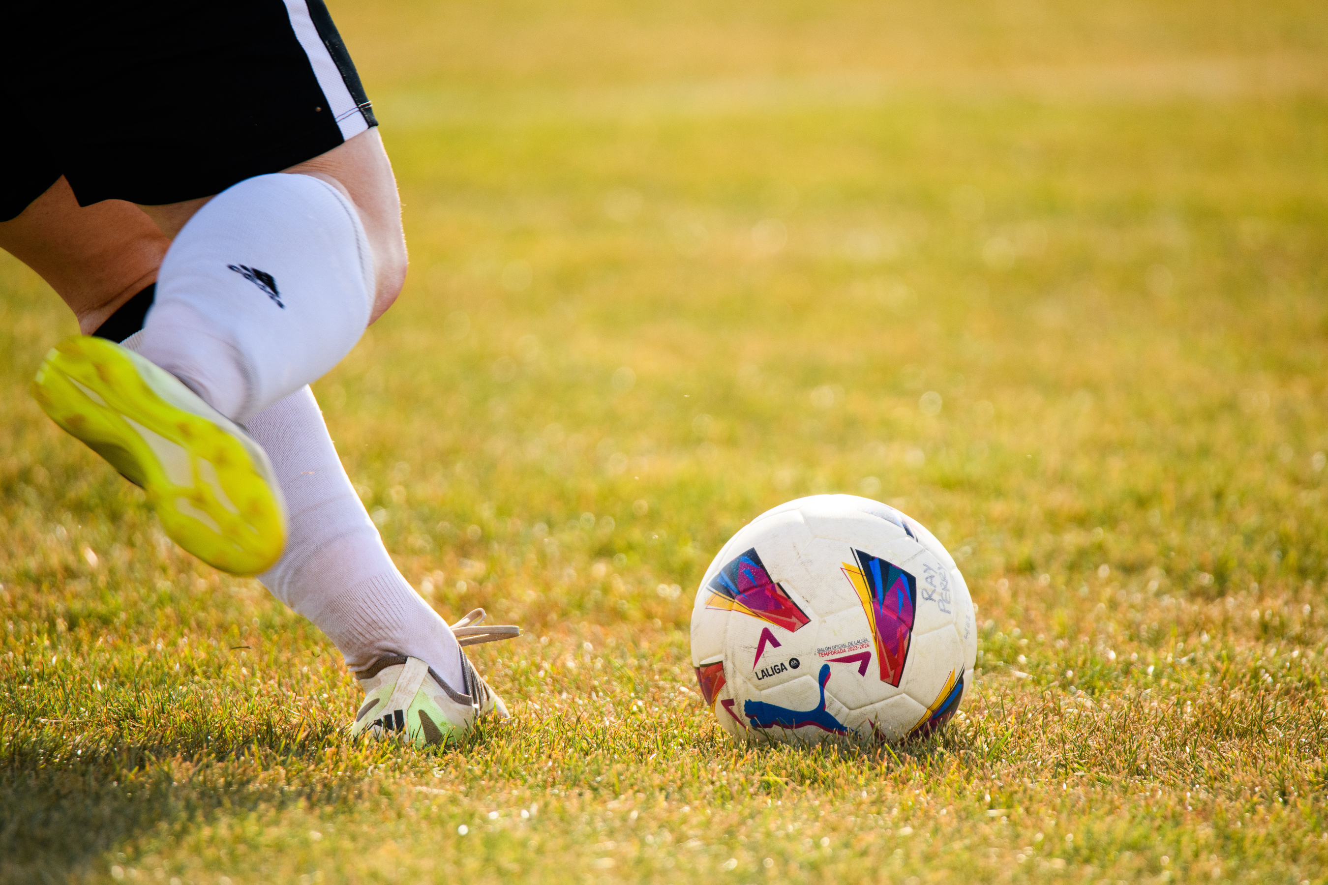 an athlete preparing to kick a soccer ball