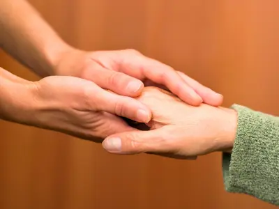 A close up of one person holding another person's hand