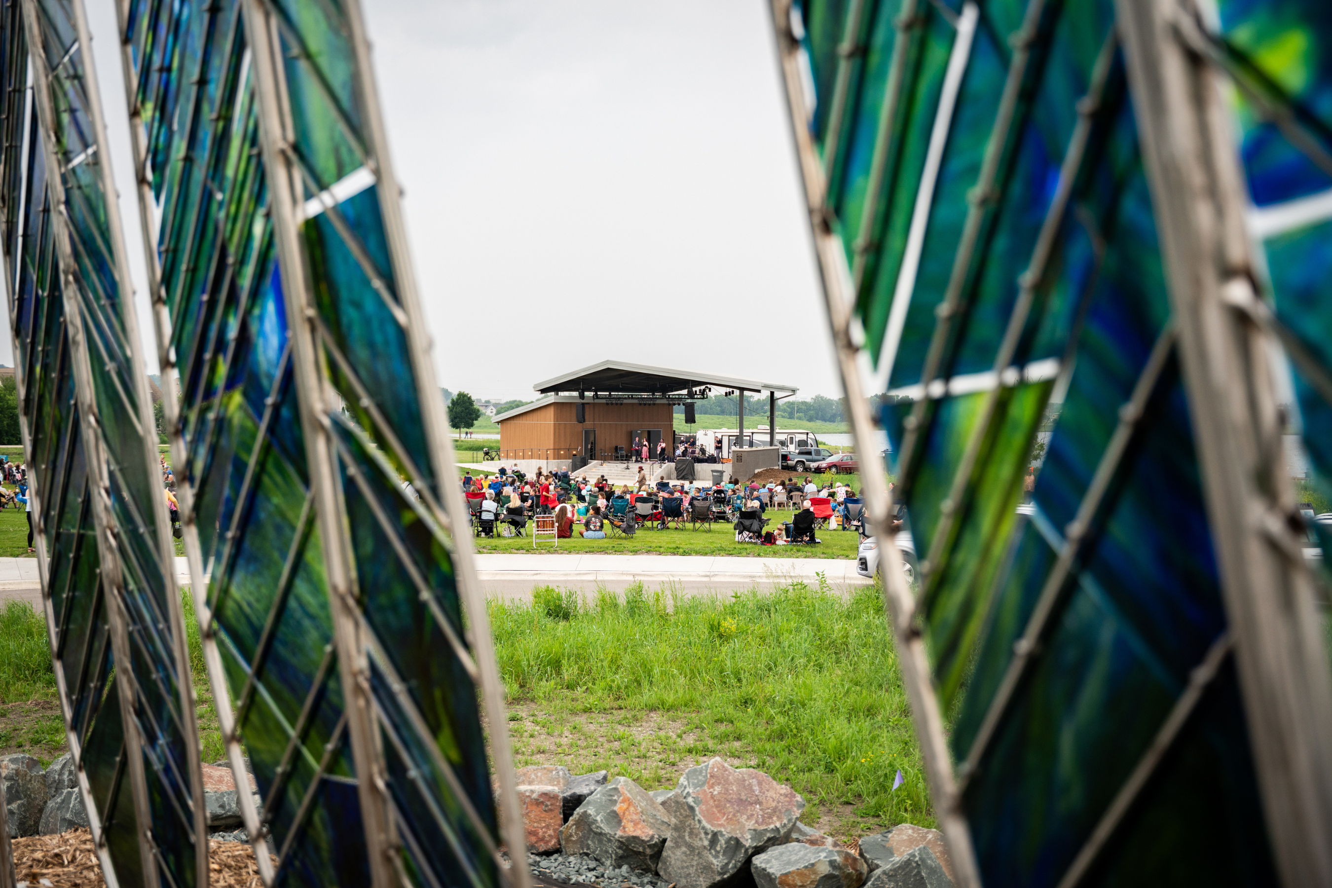 peeking through glass art to see a concert venue at an amphitheater