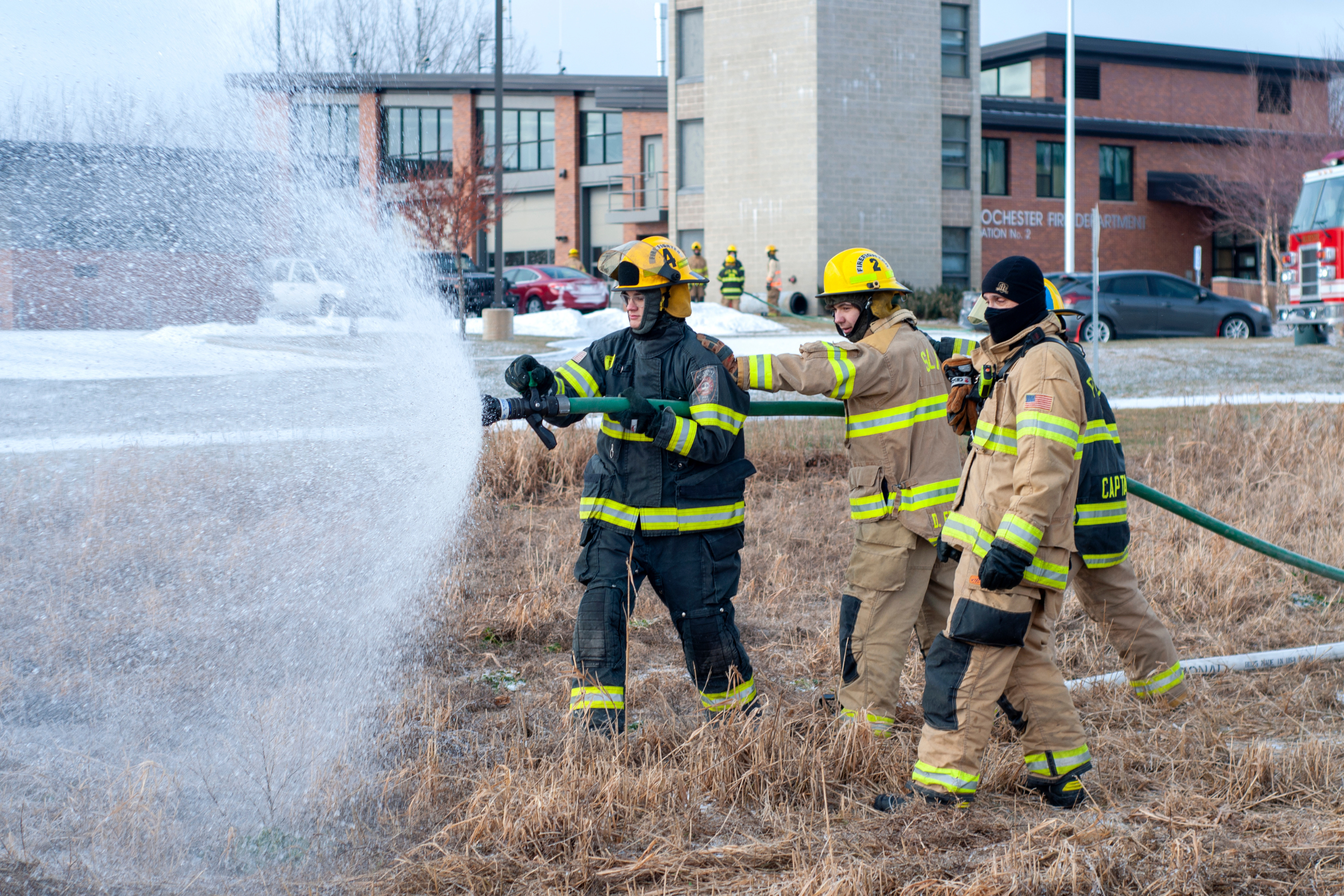 young people doing hands on firefighter training with a hose