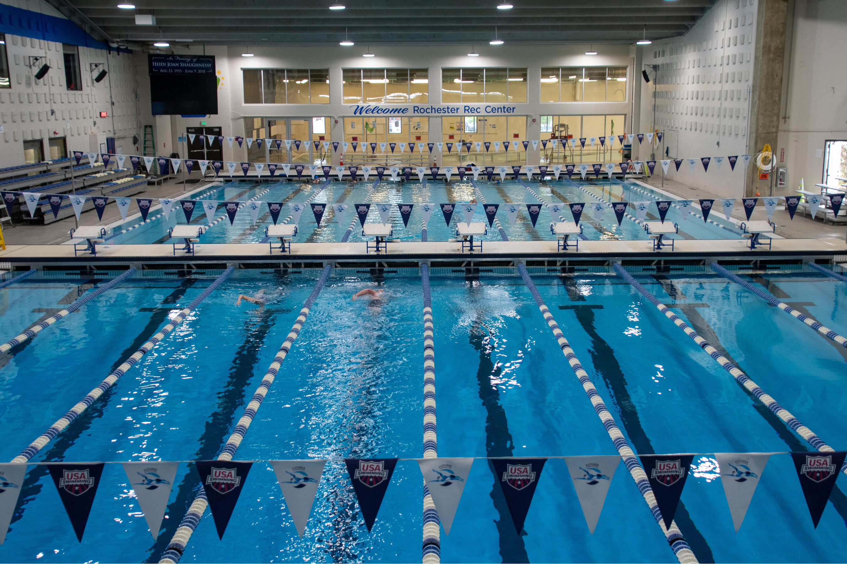 multi-lane indoor lap pool. a sign reading 'welcome rochester rec center'