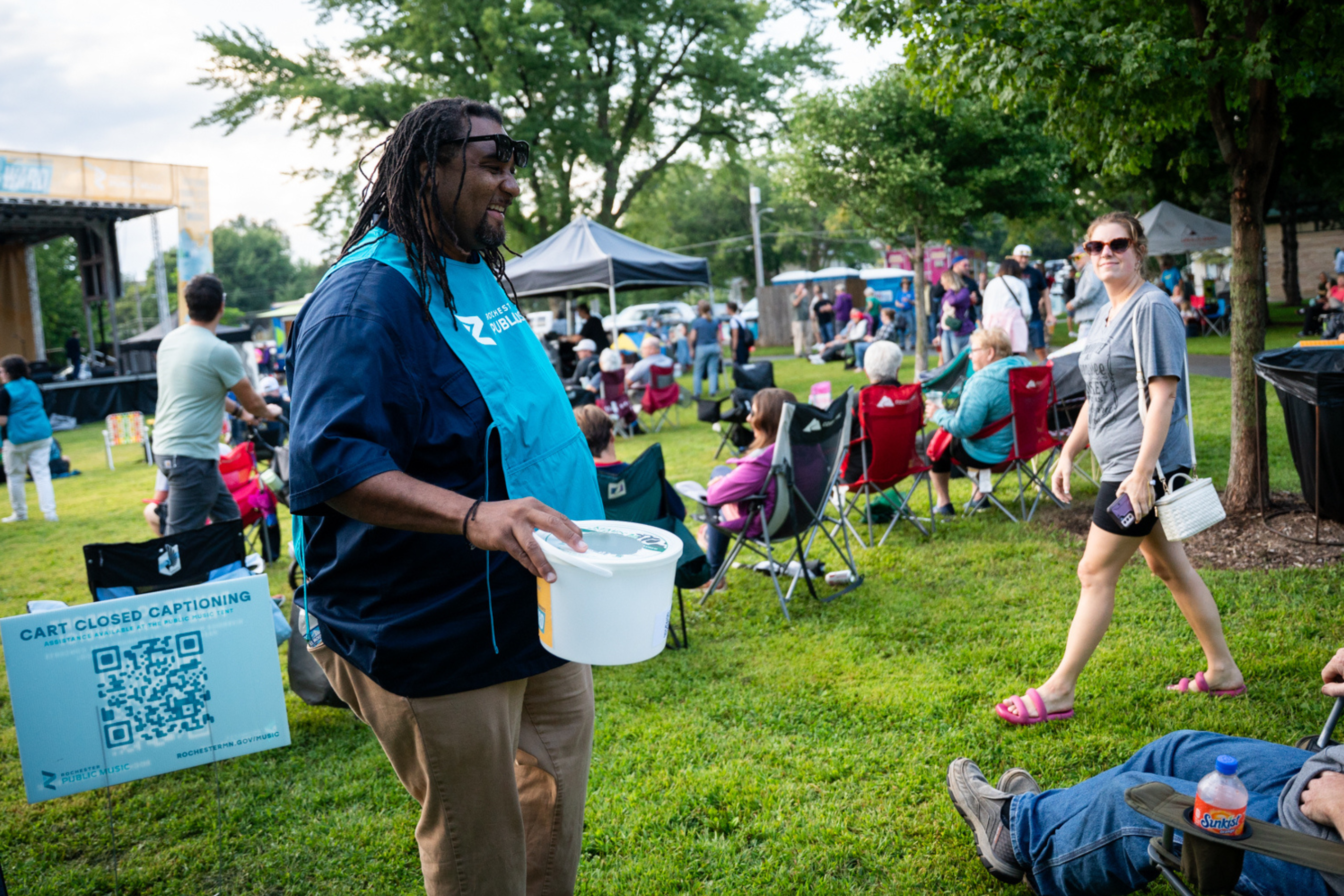 a person holding a bucket and wearing a rochester public music apron