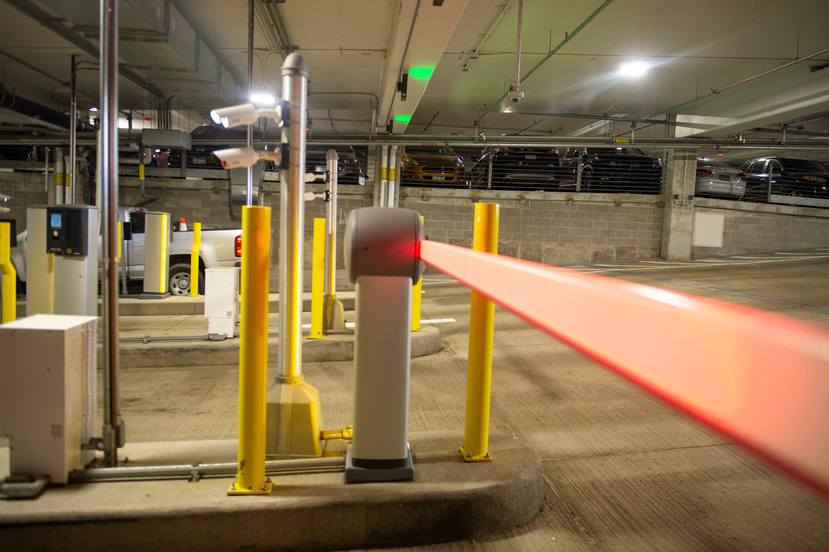 an orange stop arm inside a concrete parking ramp