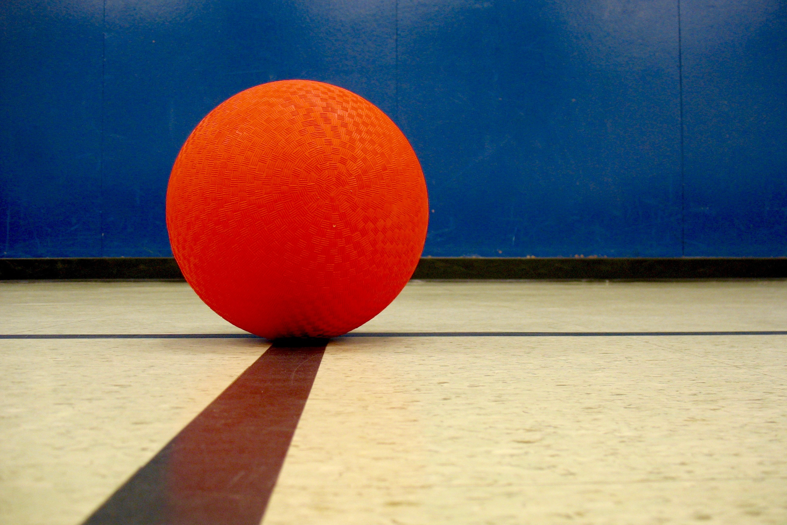 close up view of red dodgeball on a gymnasium floor