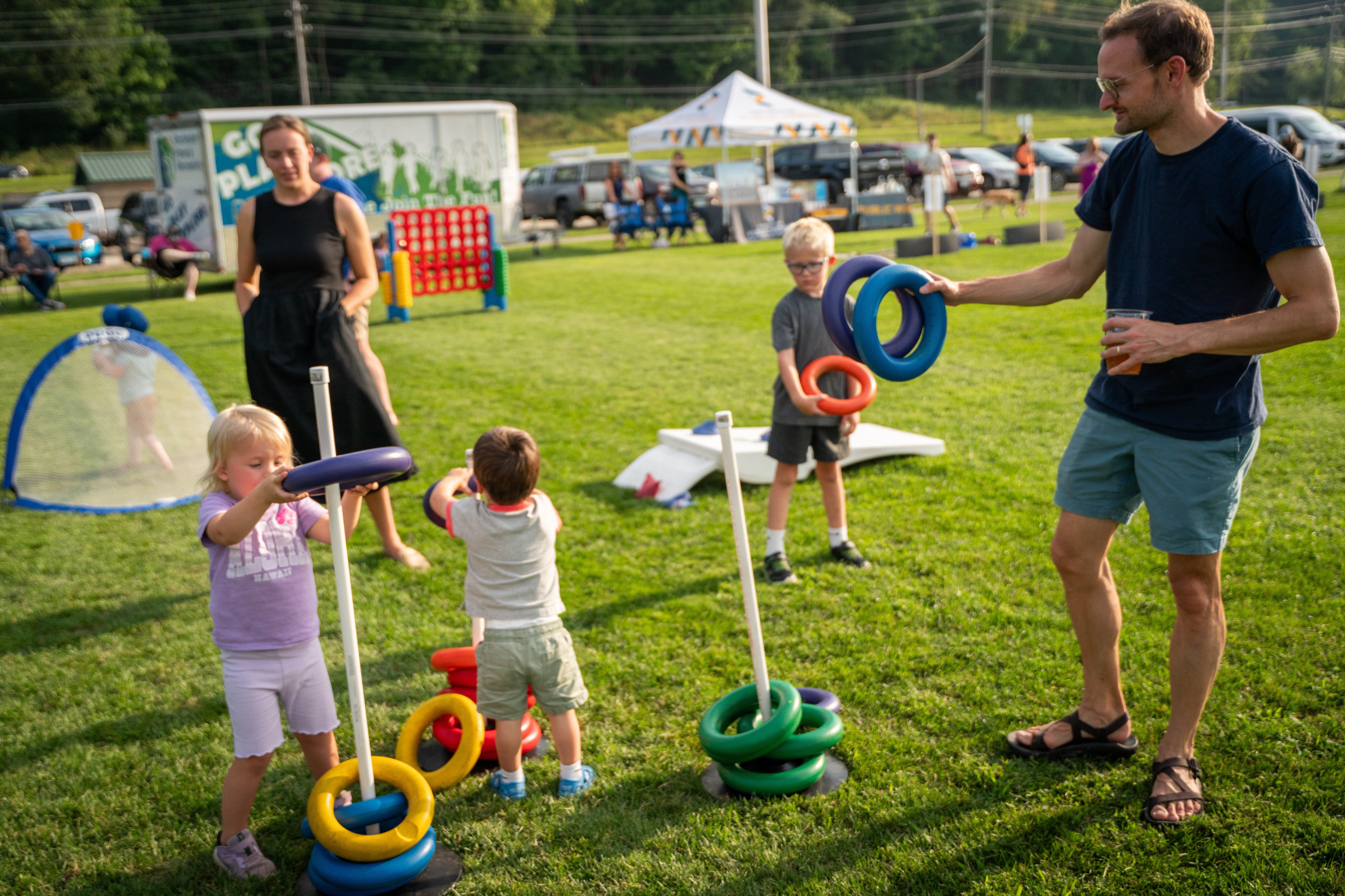 a family playing a ring toss game in a grassy area