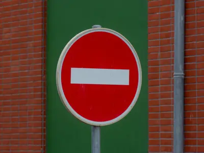 A red street sign with a horizontal white dash in the middle