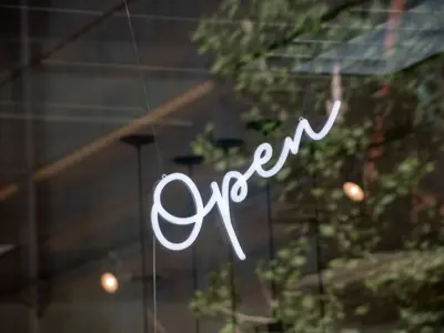 a white neon open sign in the window of an undefined business