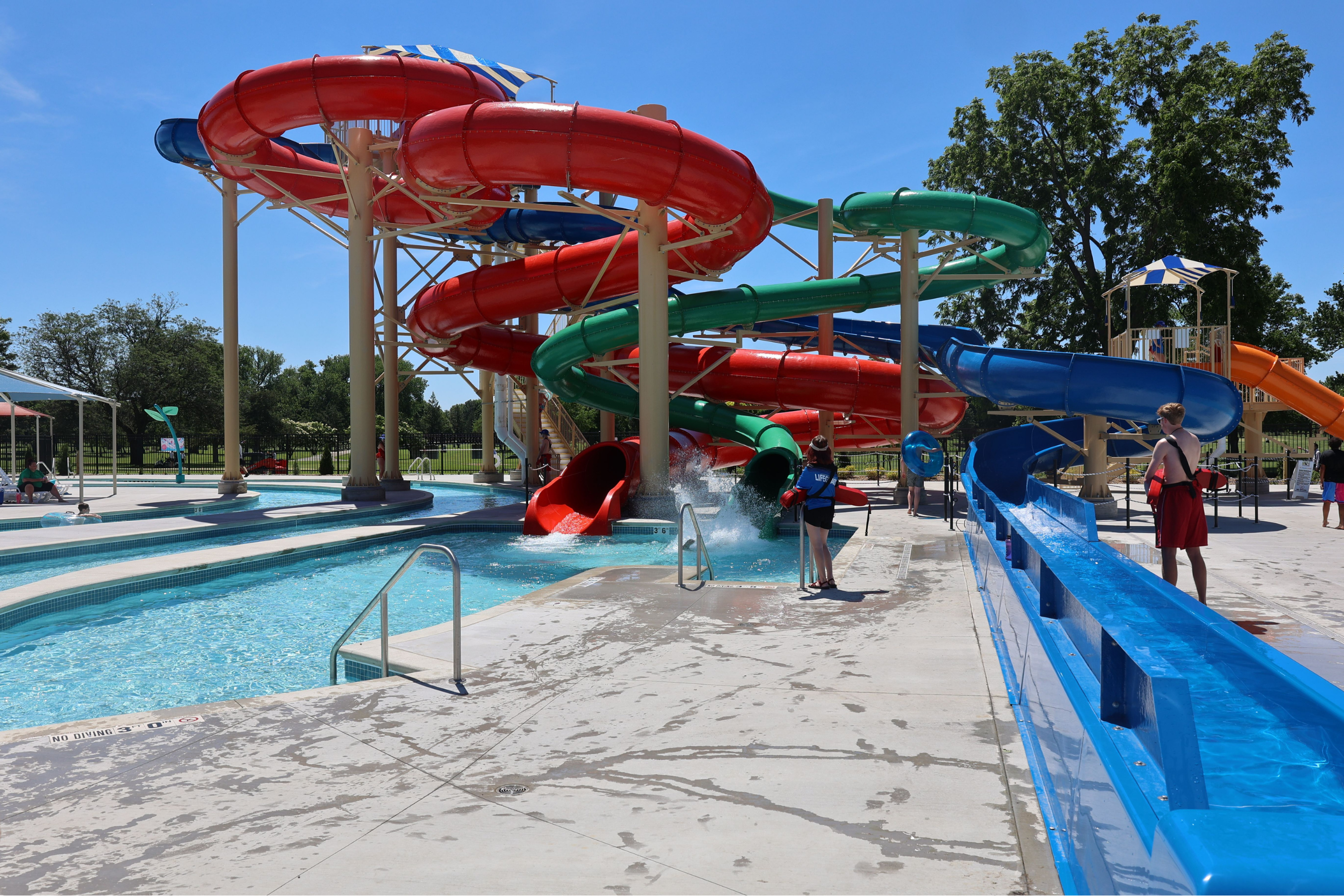 three waterslides entangled together and coming out in various areas of a pool and lazy river