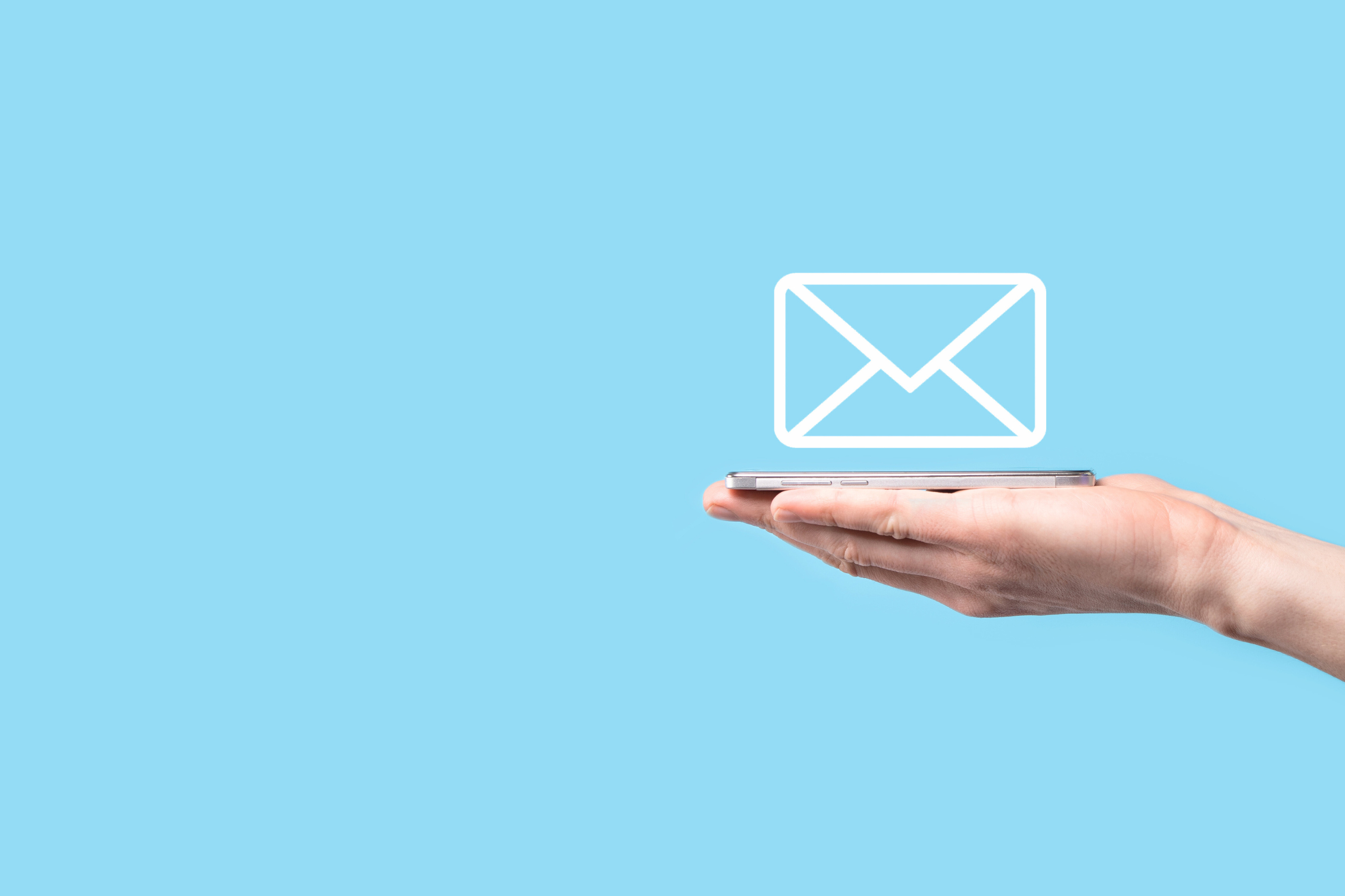 a mail icon appearing over a phone in an outstretched hand