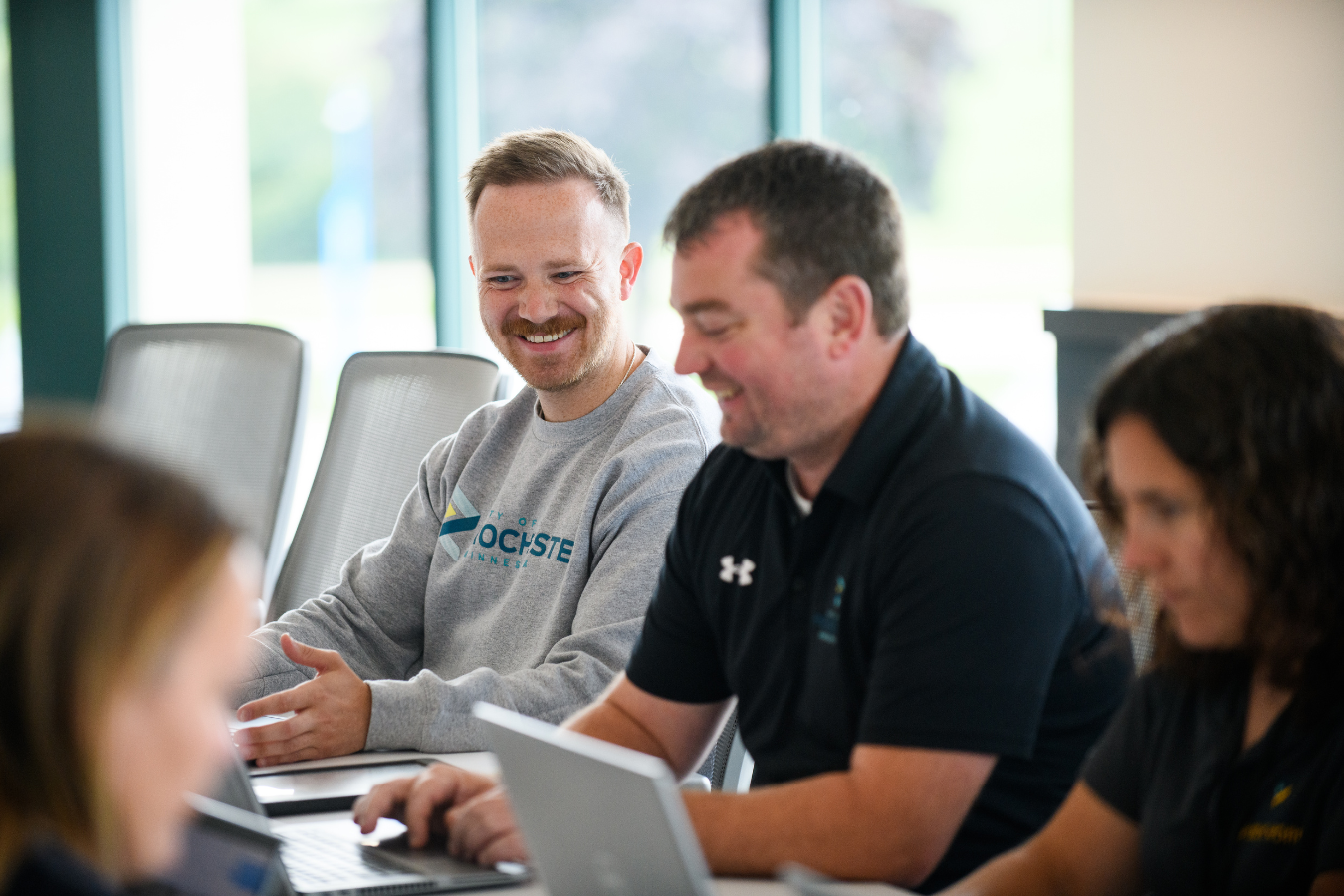 several people sitting at a conference table and smiling
