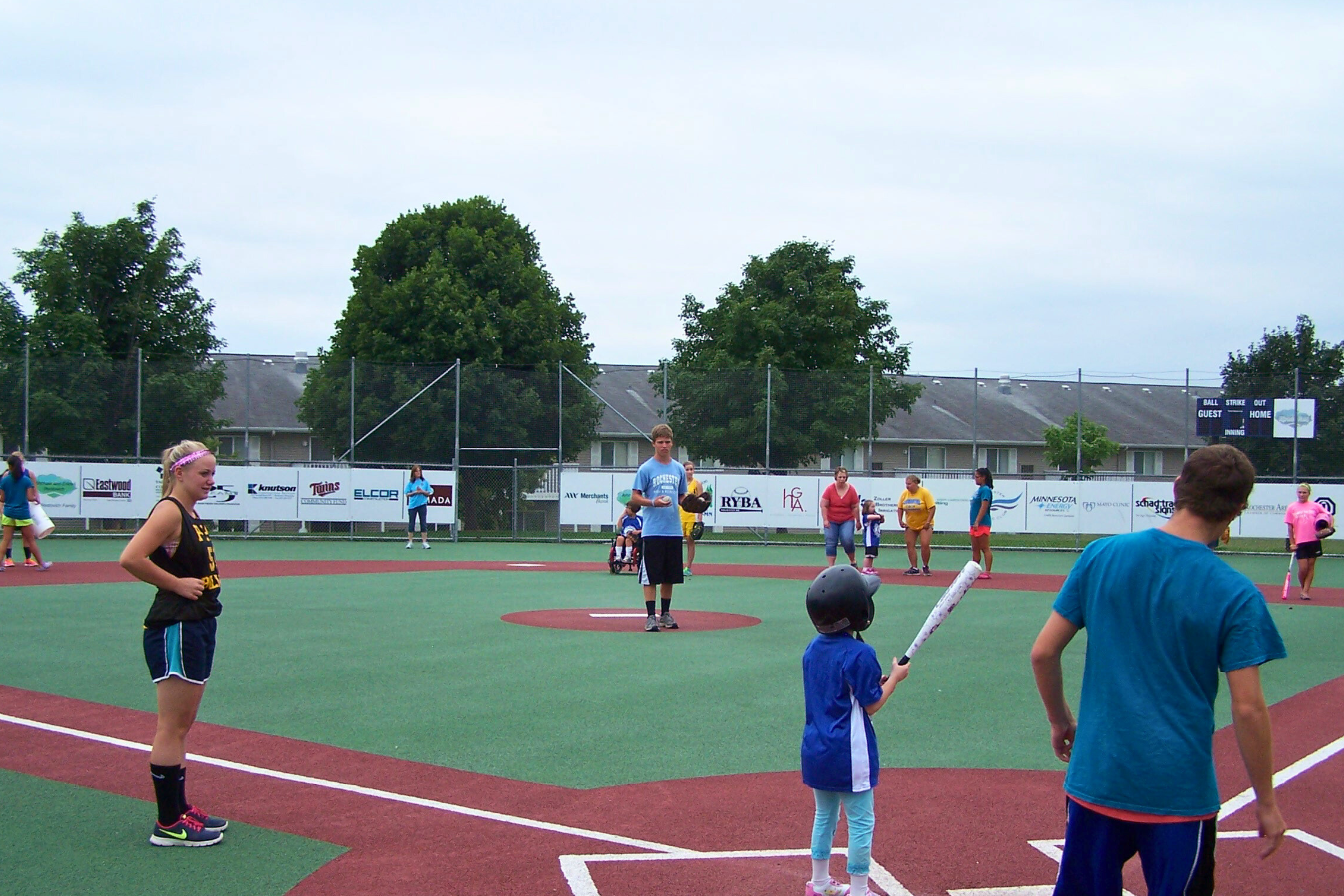 people of multiple abilities playing baseball on an accessible field