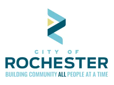 The City of Rochester logo featuring a stylized blue "R" with a gold triangle at the center above the words "City of Rochester" in blue. Below is the tagline, "Building Community All People At a Time," with "All People" highlighted in dark blue.