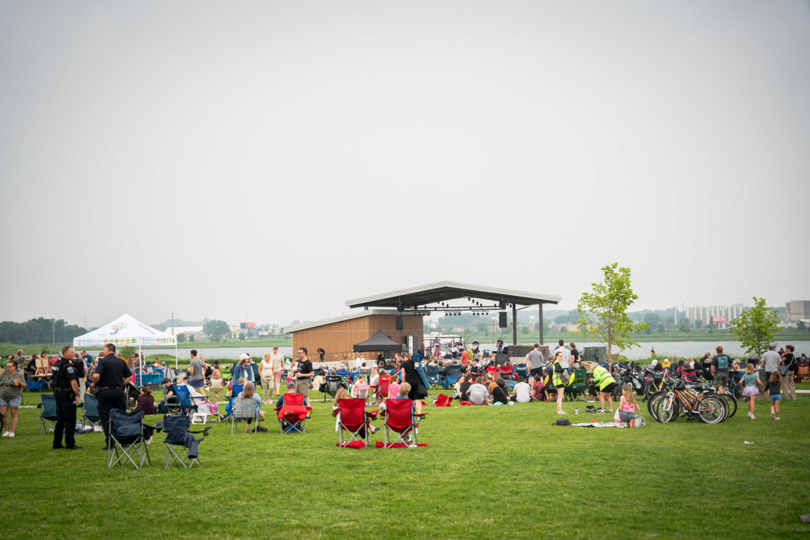 large crowd of people gathered in a park in front of an amphitheater