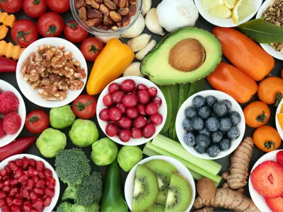 a top-down view of a table of fruits, vegetables, nuts and other healthy foods