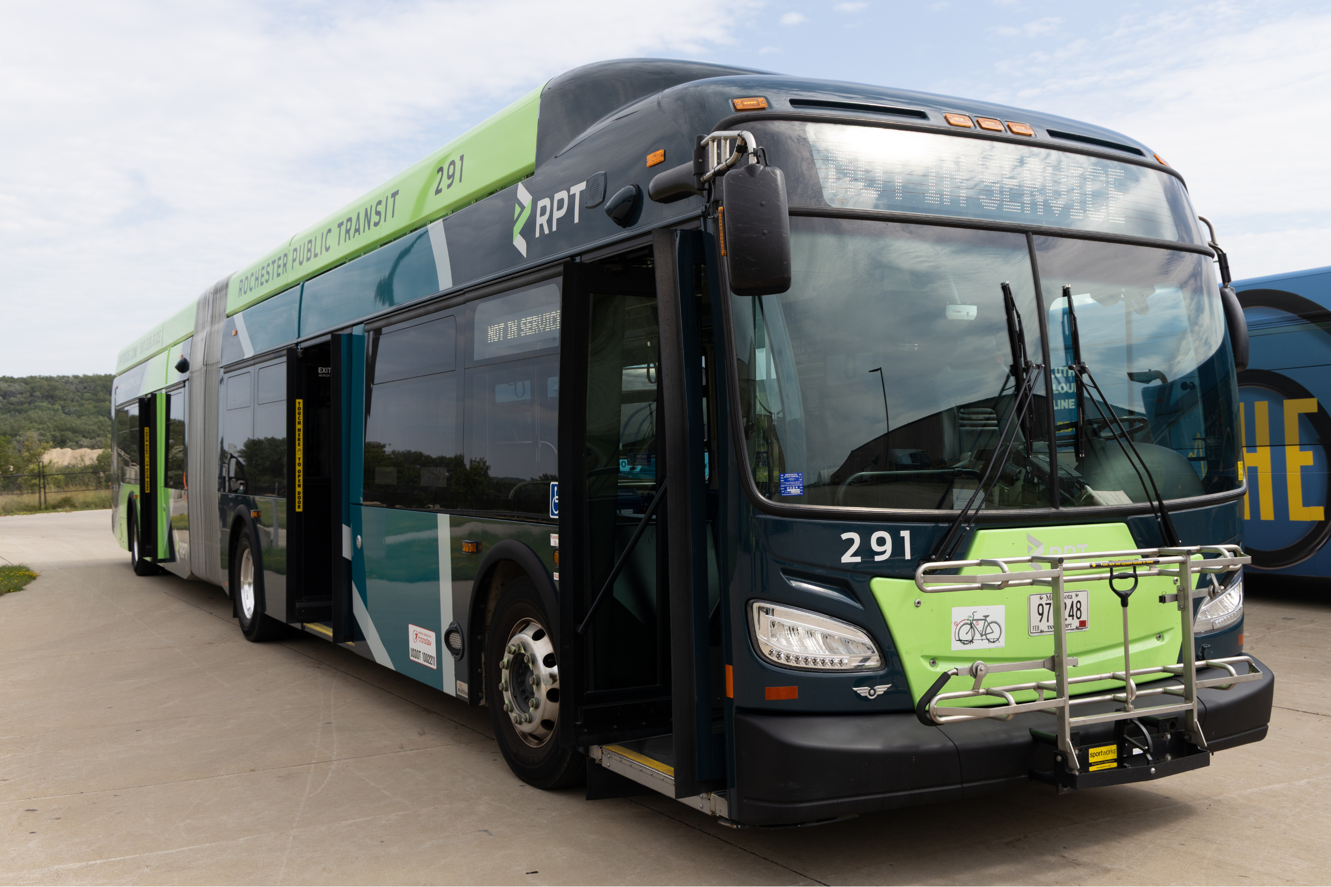 An extra-long transit bus outdoors on a cloudy day