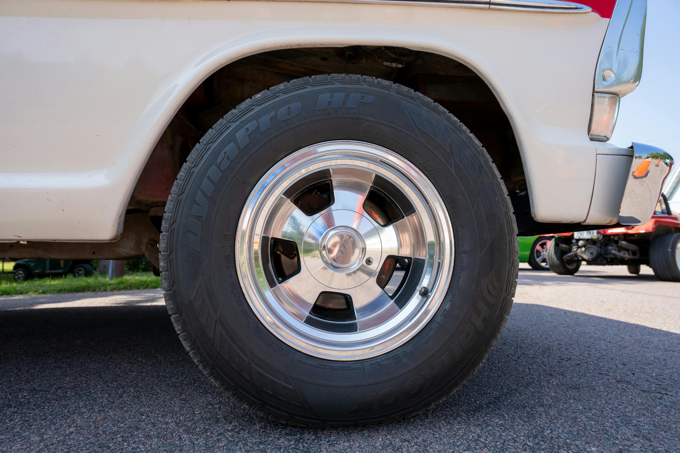 a rear tire on the driver's side of a tan vehicle